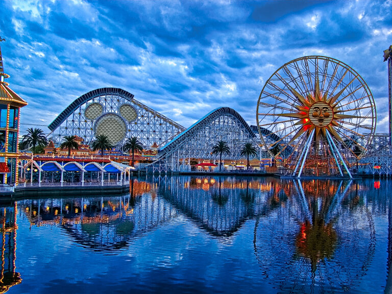 The bright colorful lights of Disney's California Adventure amusement park is reflected in the lake