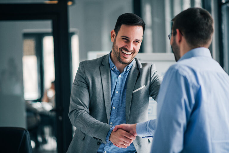 Portrait of cheerful young manager handshake with new employee.